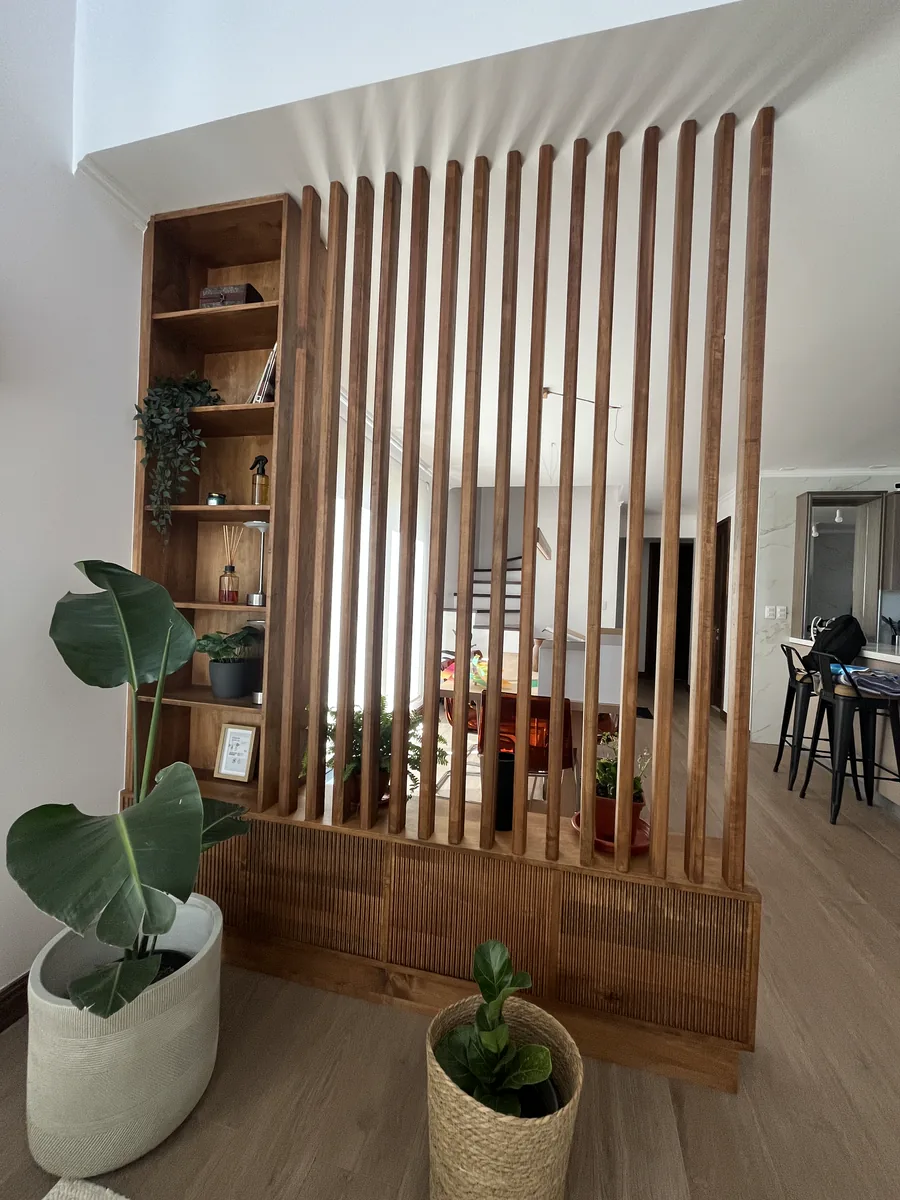 Divisor de ambientes con listones verticales y repisas