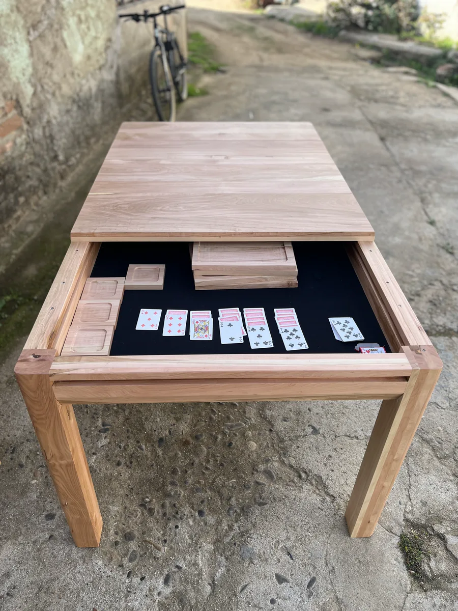 Mesa de juegos con cartas y cubiertas de madera parcialmente retiradas